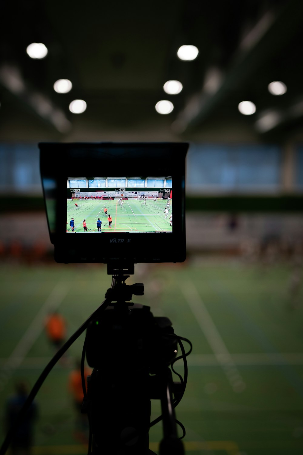 Broadcast camera monitoring a soccer match from inside the stadium